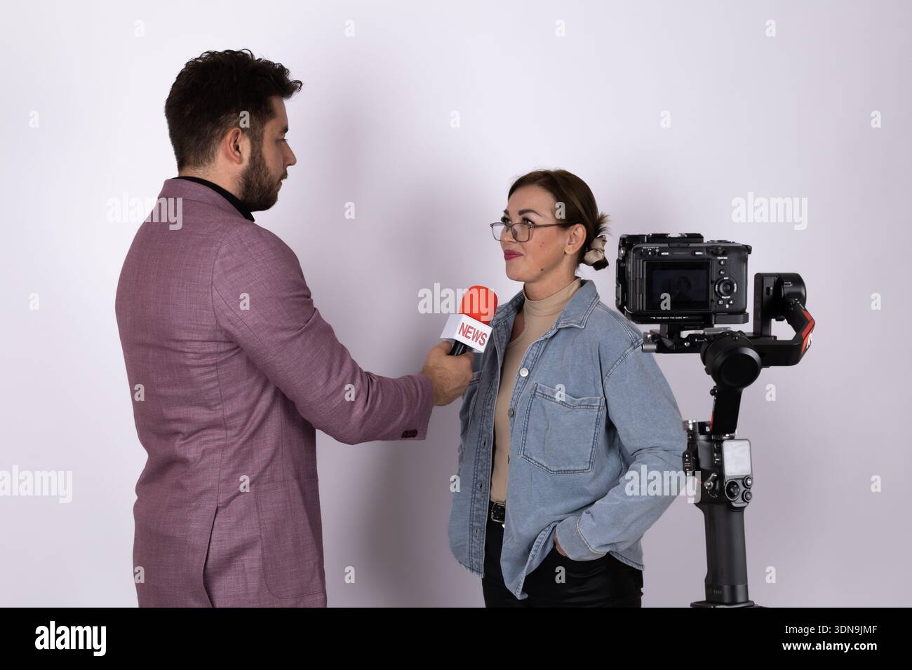 Ein Journalist interviewt eine Frau mit Mikrofon Stockfoto