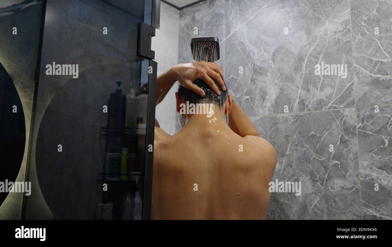 Mann unter der Dusche und Waschmaschine sein Haar Stockfoto
