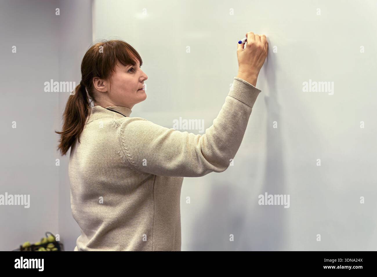 Frau schrieb auf einem Whiteboard in einem modernen Büro, illustrierte Teamarbeit und Brainstorming in einer kreativen Atmosphäre voller Inspiration Stockfoto