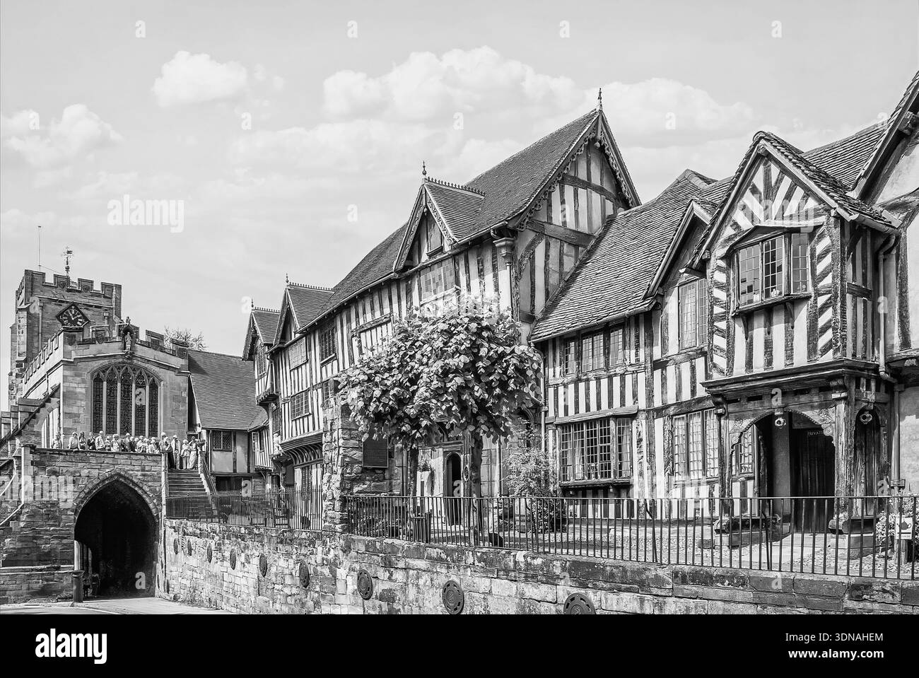Lord Leycester Hospital in Warwick, England, mit historischen Tudor-Fachwerkhäusern neben dem mittelalterlichen West Gate in Schwarz-weiß. Stockfoto