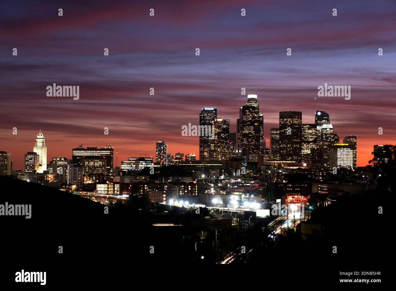 Rosa und violette Wolken nach Sonnenuntergang mit Blick auf die Innenstadt von Los Angeles, Kalifornien, einschließlich des Rathausturms Stockfoto
