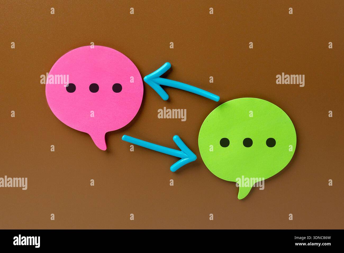Rosafarbene und grüne Sprechblasen sind durch zwei Pfeile miteinander verbunden. Feedback-Schleife und iteratives Kommunikationszykluskonzept. Stockfoto