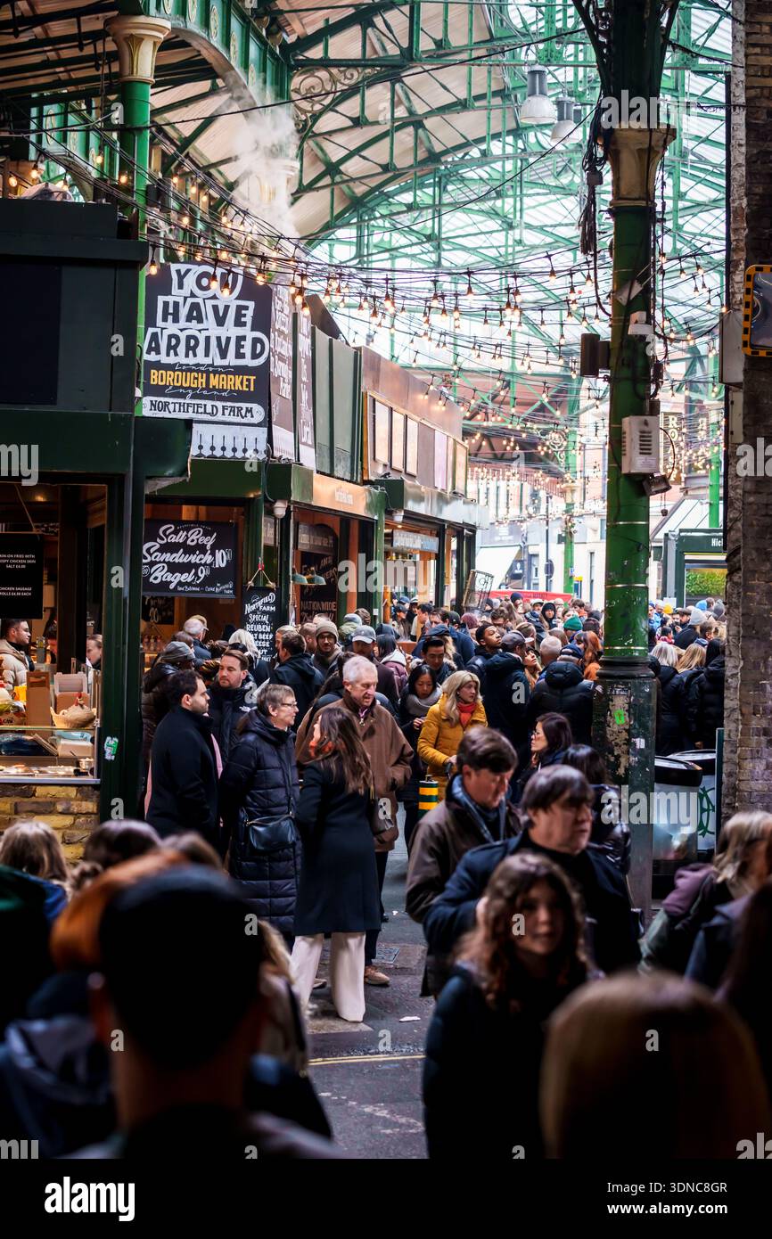 LONDON, GROSSBRITANNIEN. Februar 2025. Menschenmassen erkunden den historischen Borough Market in London, England, mit festlichen Lichtern und Industriezweigen Stockfoto