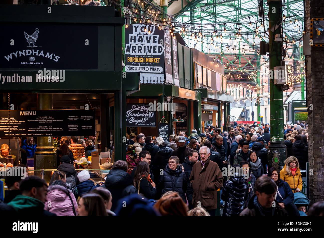 LONDON, GROSSBRITANNIEN. Februar 2025. Menschenmassen erkunden den historischen Borough Market in London, England, mit festlichen Lichtern und Industriezweigen Stockfoto