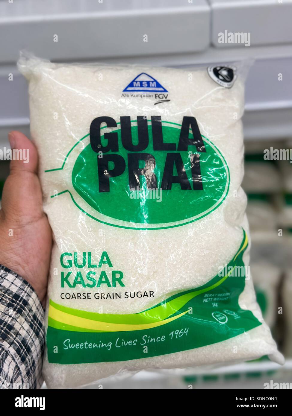 Johor, Malaysia, 10. Februar 2026: Hand hält Gula Prai grobkörniges Zuckerpaket im Supermarkt. Stockfoto