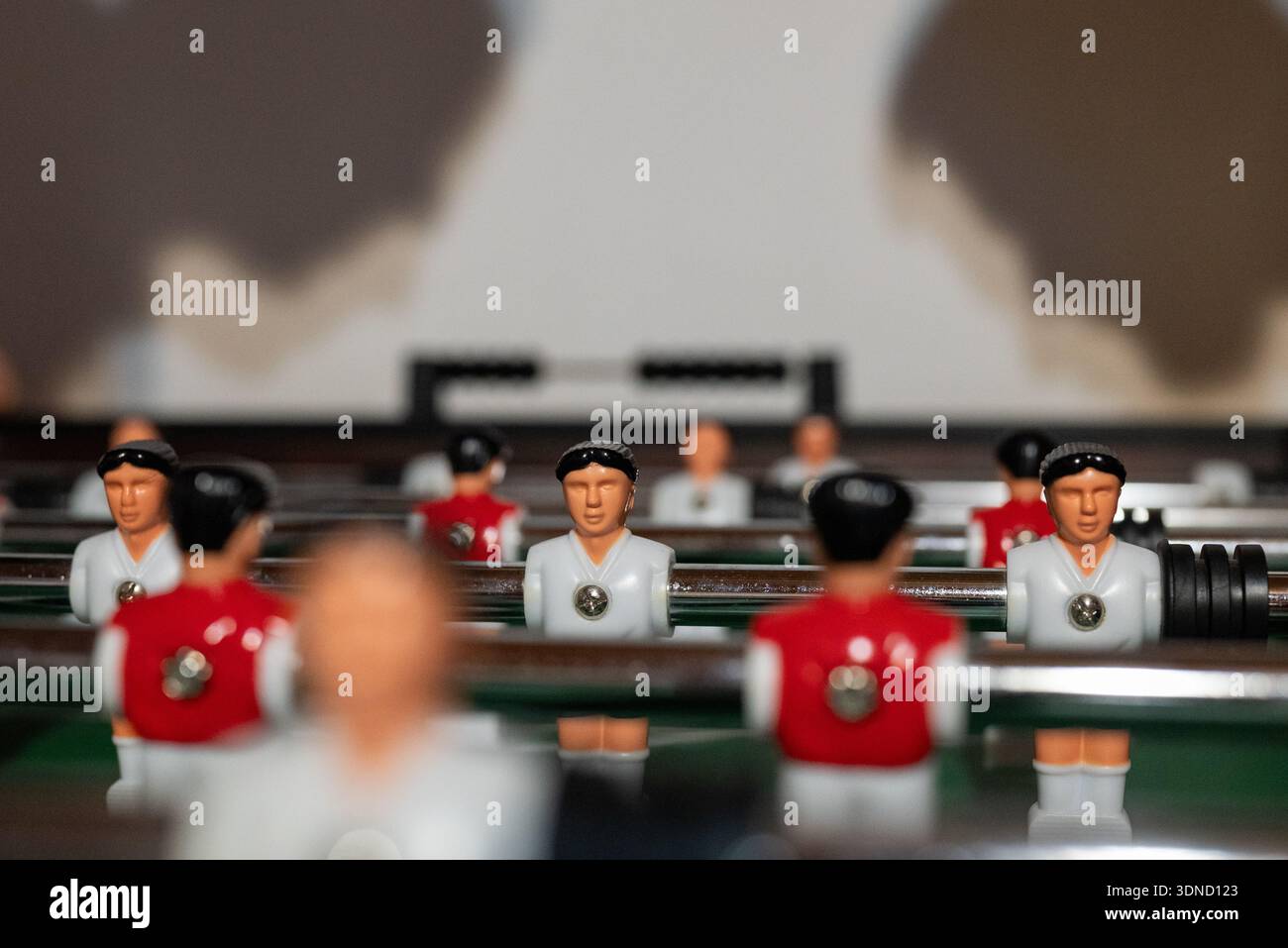 Tischfußballspiel mit Spielerschatten an der Wand Stockfoto