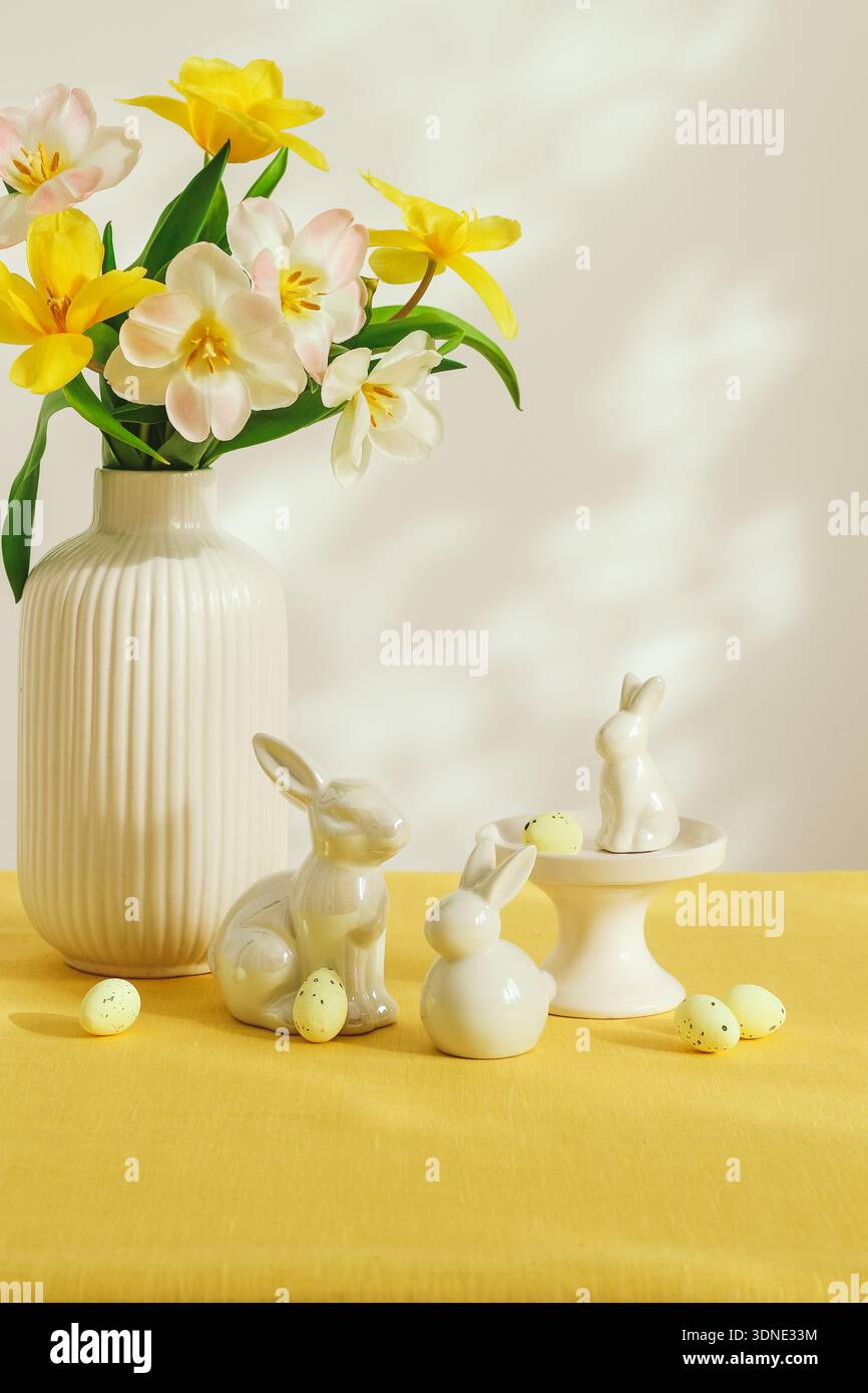 Heller Ostertisch mit Tulpenblumen, Häschen und dekorativen Eiern Stockfoto