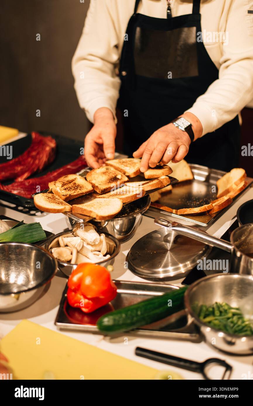 Der Koch legt geröstetes Brot aus. Hochwertige Fotos Stockfoto