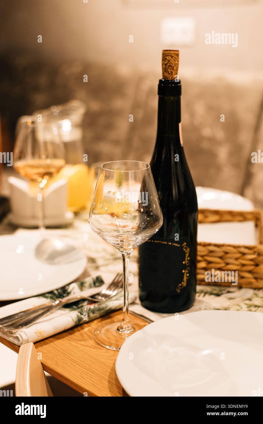 Ein Glas und eine Flasche Wein auf einem gedeckten Tisch. Hochwertige Fotos Stockfoto