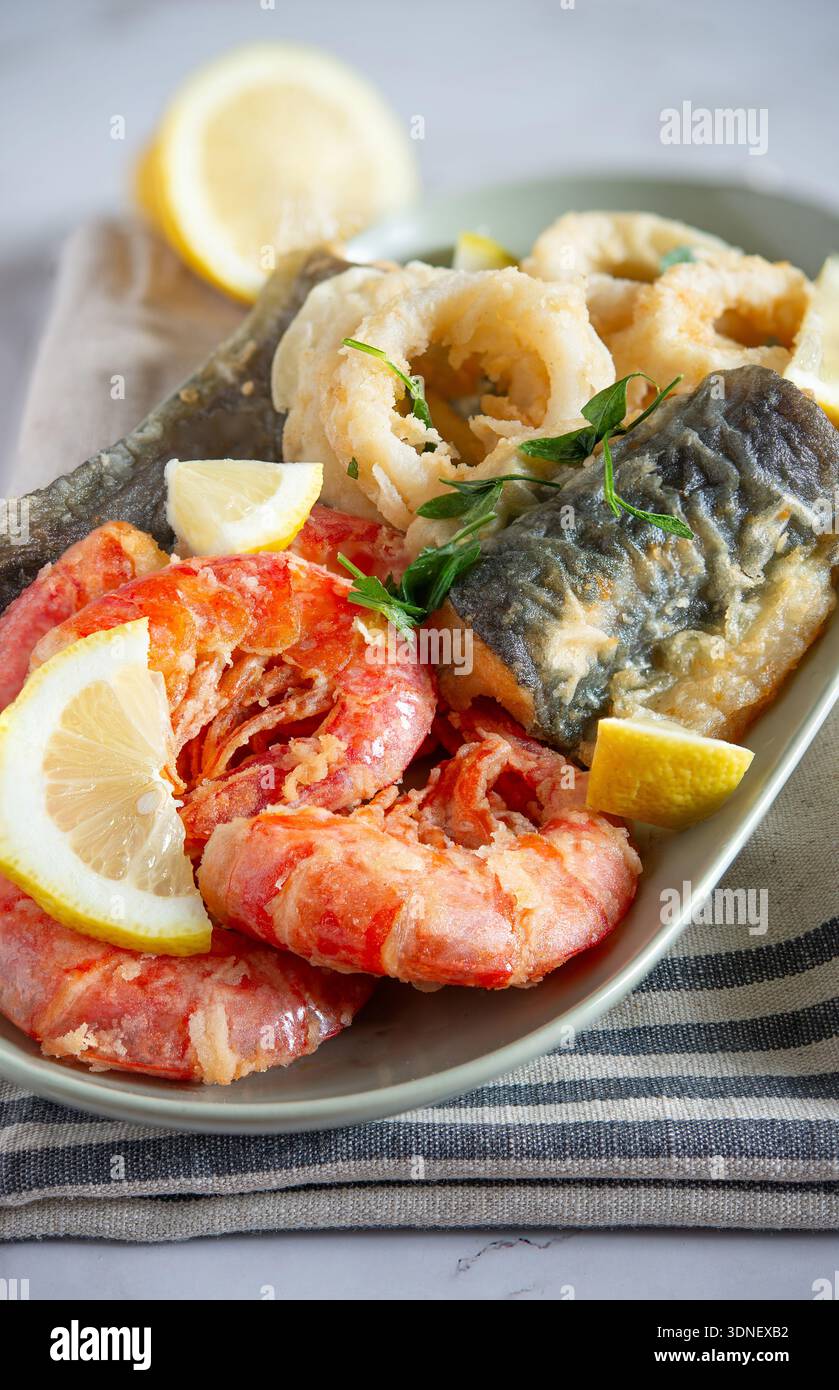 Gebratene Meeresfrüchte-Platte mit knusprigen Garnelen, Calamari-Ringen und Aal mit Zitrone Stockfoto