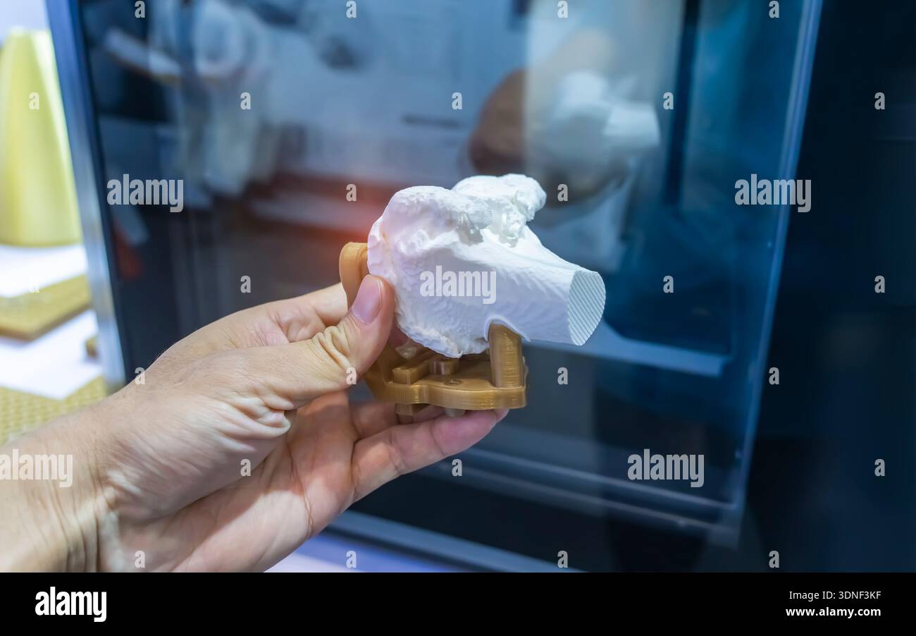 Hand mit 3D-gedrucktem menschlichen Beinknochen in 3D-Drucker.Beinknochen Stockfoto