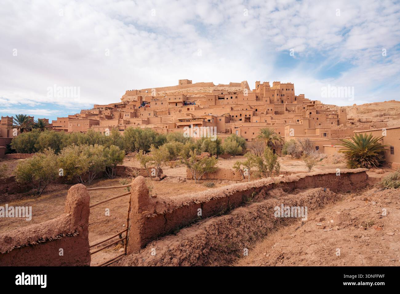 Marokkanische Kasbah Ait Ben Haddou mit Palmen und Touristen erkunden Stockfoto