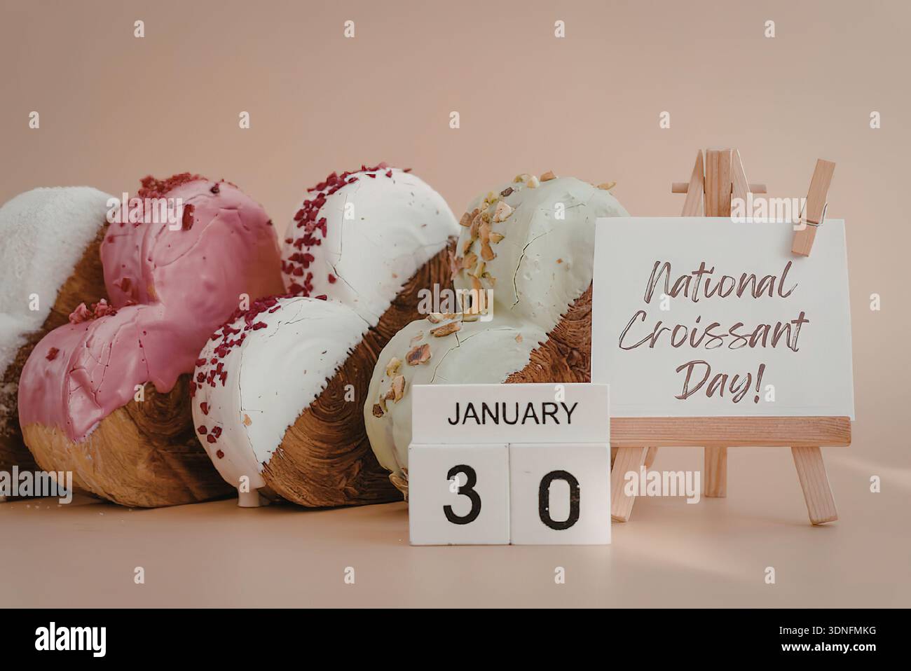 Ein köstliches Arrangement von Croissants auf einem Tisch mit einem Schild, das den Nationalfeiertag am 30. Januar feiert. Stockfoto