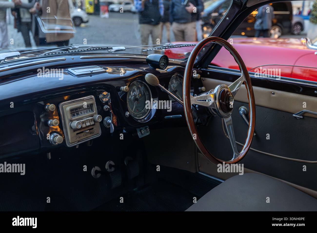 Rom, Italien - 17. Januar 2026: Das sorgfältig erhaltene Interieur einer alten Lancia mit einem hölzernen Lenkrad und analogen Anzeigen, reflektiert Stockfoto