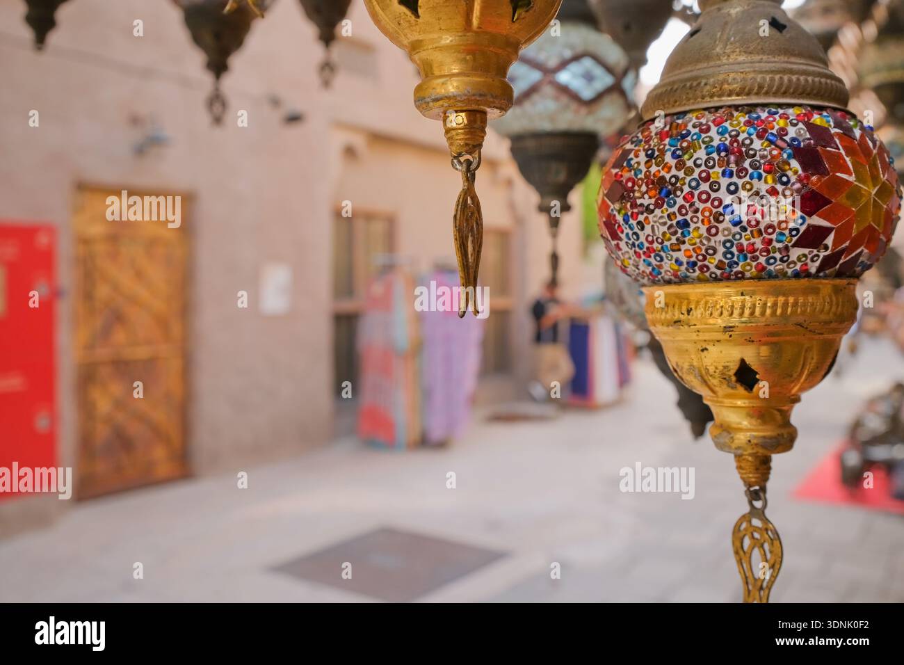 Traditionelle Mosaiklaternen hängen in der Souk Street des Nahen Ostens. Farbenfrohe handgefertigte Lampen schaffen authentische orientalische Atmosphäre Stockfoto