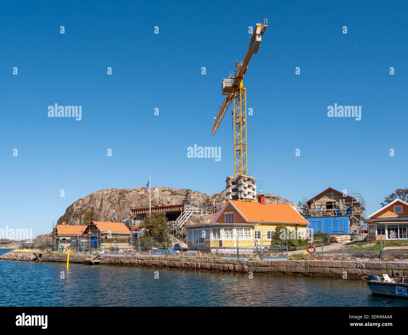 Im Bau befindliche Uferhäuser und Turmkran bei Katteklåvan in Hamburgsund, Bohuslän, Västra Götaland, Westküste Schwedens, von der Meerenge aus gesehen Stockfoto