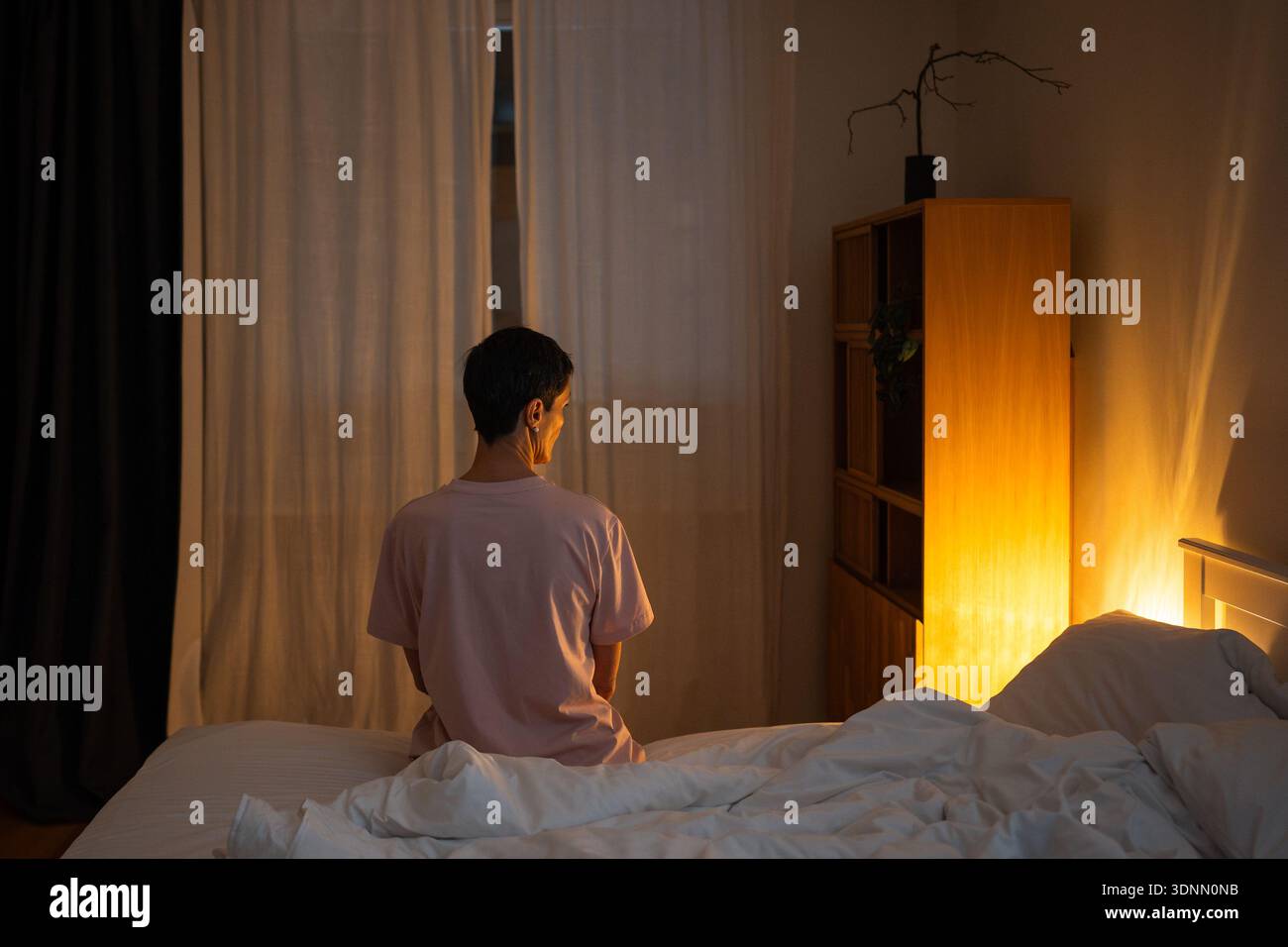 Nachdenkliche einsame Seniorin, die spät nachts im Bett sitzt und über Lebensprobleme und Sorgen nachdenkt. Stockfoto