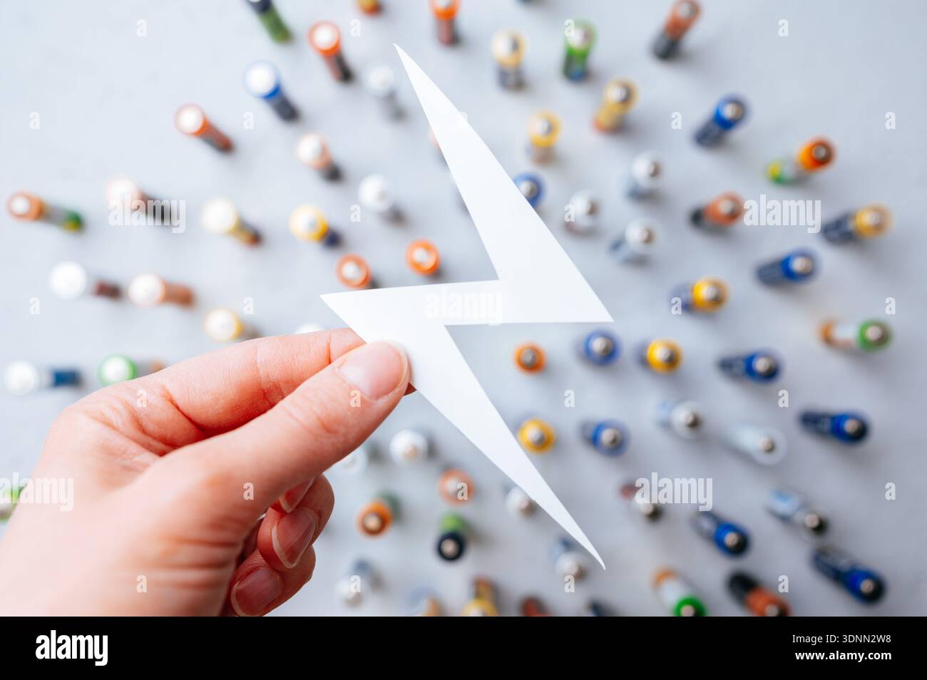 Handballenkupplung Blitz An Batterien. Nahaufnahme Der Hand, Die Das Blitzsymbol Über Den Batterien Hält Stockfoto