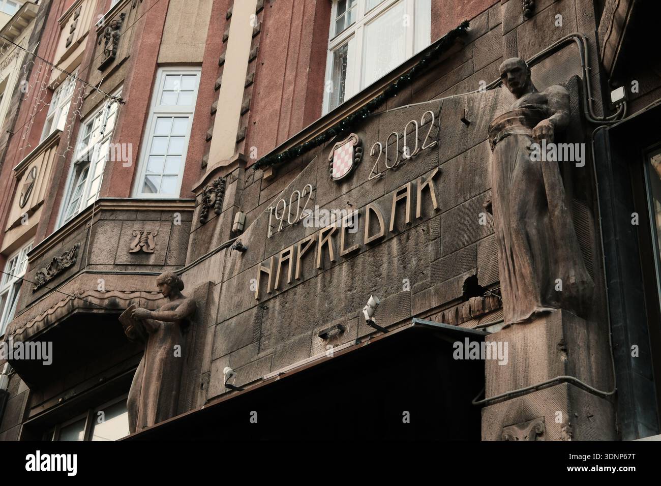 Steinfassade mit Skulpturenfiguren und historischer Inschrift in der Architektur des Zentrums von Sarajevo. Sarajevo, Bosnien und Herzegowina - 15. Dezember Stockfoto
