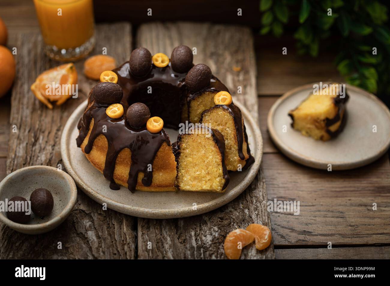 Bundt-Kuchen mit Zitrusfrüchten, Schokoladenglasur und Schokoladeneiern Stockfoto