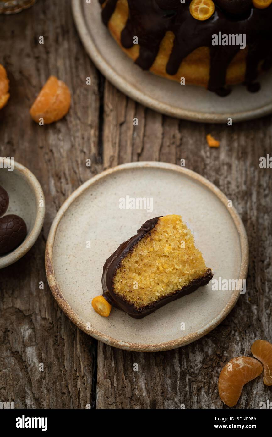 Bundt-Kuchen mit Zitrusfrüchten, Schokoladenglasur und Schokoladeneiern Stockfoto