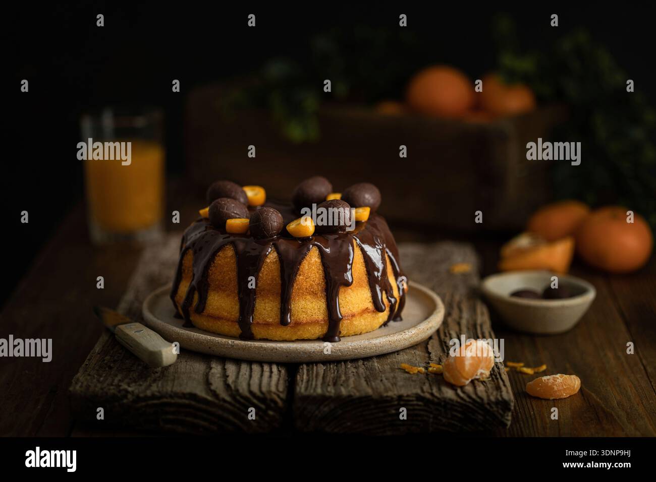 Bundt-Kuchen mit Zitrusfrüchten, Schokoladenglasur und Schokoladeneiern Stockfoto