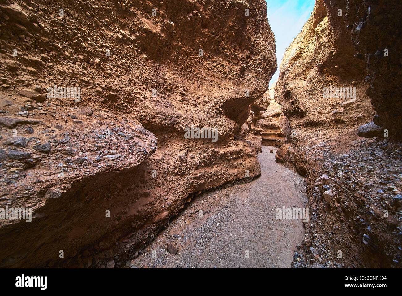 Slot Canyon Path, zerklüftete Sandsteinmauern und sonnendurchflutetes Wüstenabenteuer Stockfoto