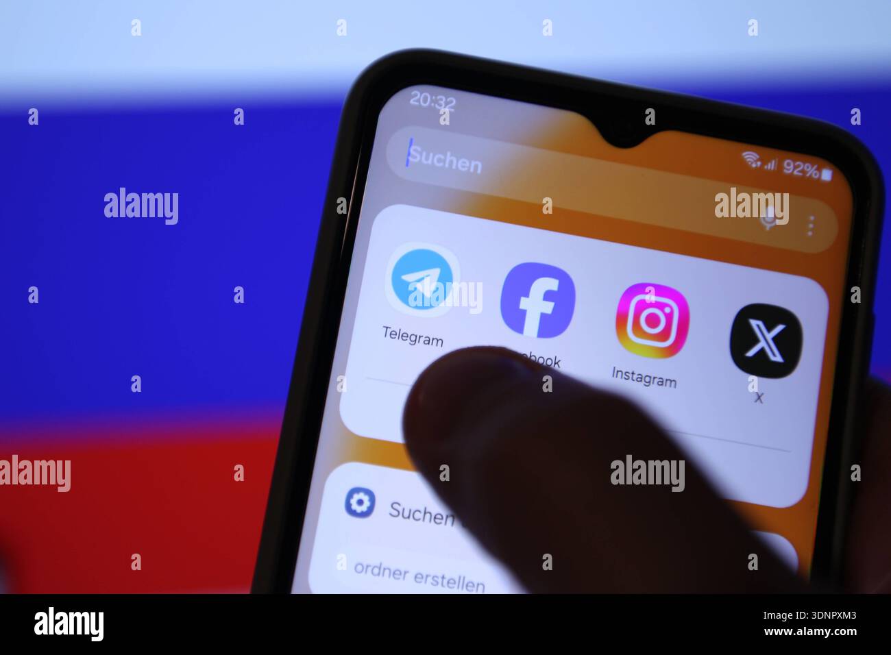 Auf einem Laptop wurde die Flagge der Russischen Föderation aufgerufen. Davor sind auf einem Smartphone verschiedene Apps zu sehen - unter anderem die von Telegram. Russland schränkt den Instant-Messaging-Dienst wegen angeblicher Rechtsverstöße ein. Die Plattform werde verlangsamt und der Zugriff auf sie erschwert, teilte die russische Medienaufsichtsbehörde Roskomnadsor der Tageschau mit. Symbolbild/Symbolfoto. Schnelsen Hamburg *** die Flagge der Russischen Föderation wurde auf einem Laptop davor aufgerufen, verschiedene Apps sind auf einem Smartphone zu sehen, darunter die von Telegram Russia is restri Stockfoto