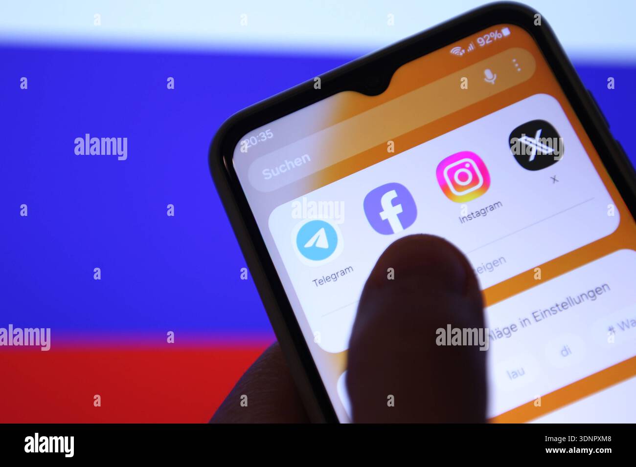 Auf einem Laptop wurde die Flagge der Russischen Föderation aufgerufen. Davor sind auf einem Smartphone verschiedene Apps zu sehen - unter anderem die von Telegram. Russland schränkt den Instant-Messaging-Dienst wegen angeblicher Rechtsverstöße ein. Die Plattform werde verlangsamt und der Zugriff auf sie erschwert, teilte die russische Medienaufsichtsbehörde Roskomnadsor der Tageschau mit. Symbolbild/Symbolfoto. Schnelsen Hamburg *** die Flagge der Russischen Föderation wurde auf einem Laptop davor aufgerufen, verschiedene Apps sind auf einem Smartphone zu sehen, darunter die von Telegram Russia is restri Stockfoto