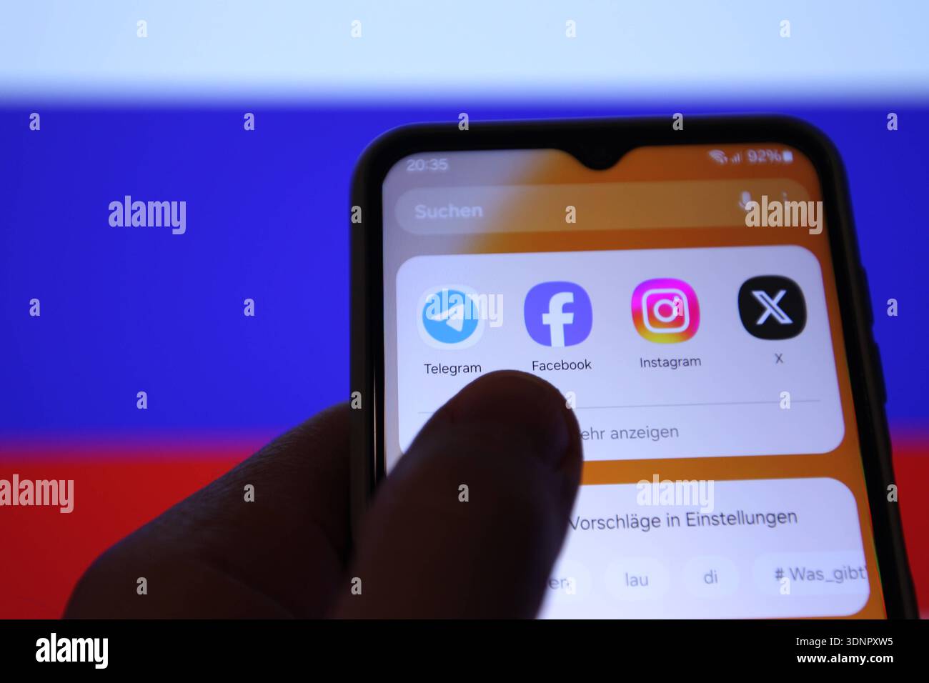 Auf einem Laptop wurde die Flagge der Russischen Föderation aufgerufen. Davor sind auf einem Smartphone verschiedene Apps zu sehen - unter anderem die von Telegram. Russland schränkt den Instant-Messaging-Dienst wegen angeblicher Rechtsverstöße ein. Die Plattform werde verlangsamt und der Zugriff auf sie erschwert, teilte die russische Medienaufsichtsbehörde Roskomnadsor der Tageschau mit. Symbolbild/Symbolfoto. Schnelsen Hamburg *** die Flagge der Russischen Föderation wurde auf einem Laptop davor aufgerufen, verschiedene Apps sind auf einem Smartphone zu sehen, darunter die von Telegram Russia is restri Stockfoto