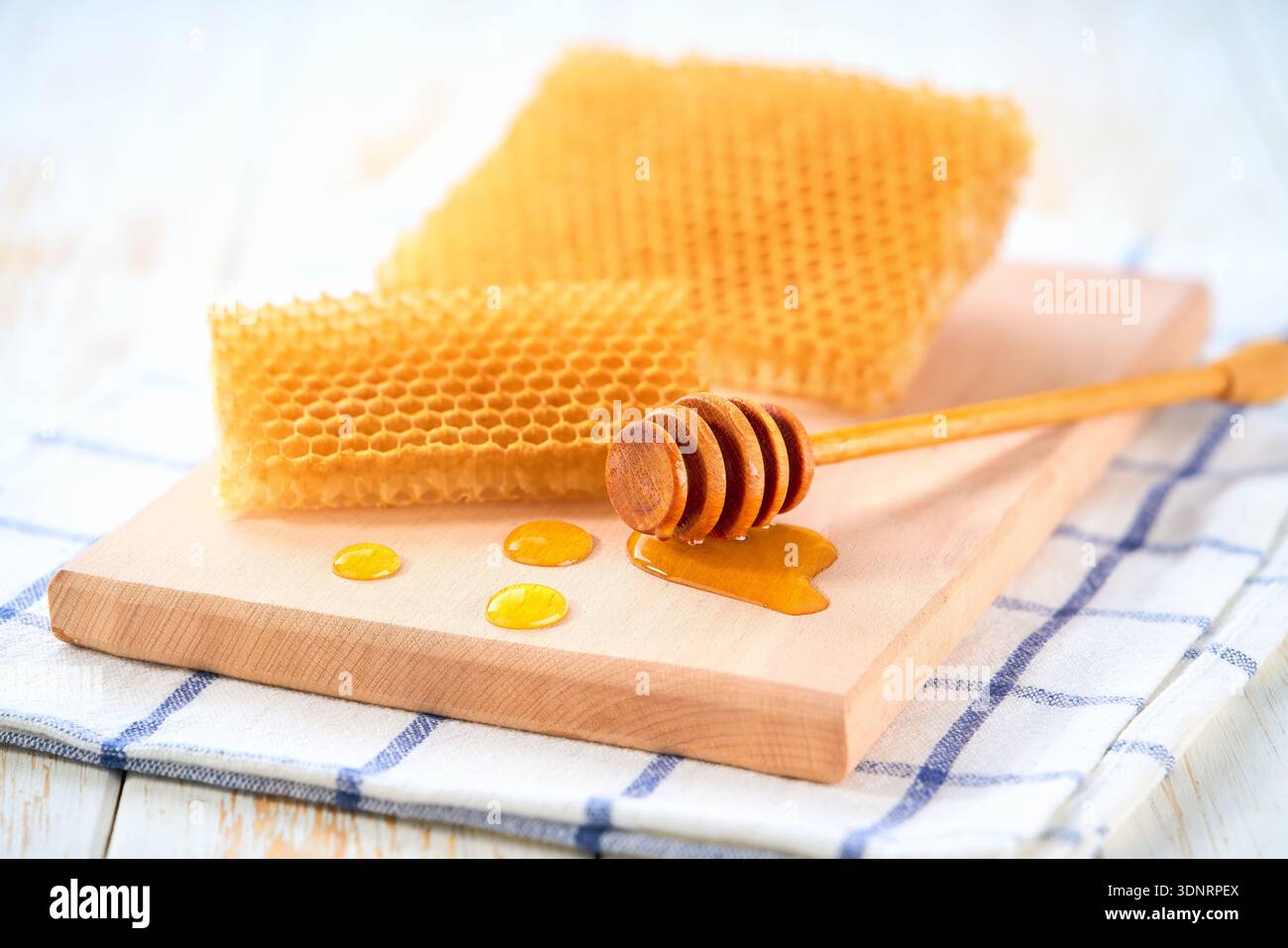 Honigwaben und flüssiger Honig auf einem Tisch. Waben und Tropfen Honig. Bienenhonig ist ein köstliches und gesundes Produkt. Stockfoto