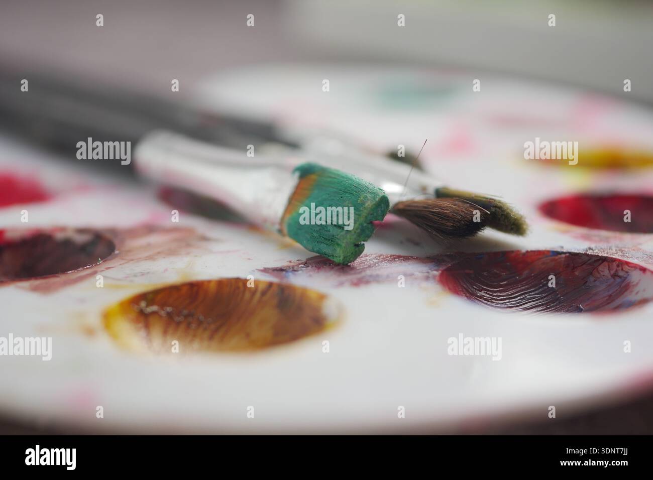 Bunte Farben und Pinsel auf einer Mischpalette Stockfoto