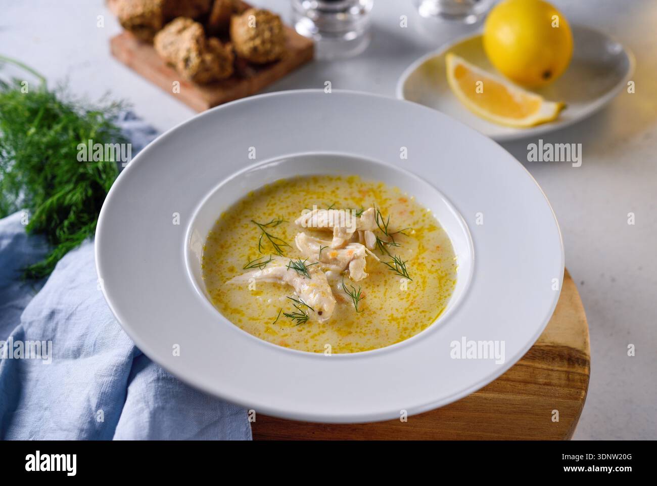 Traditionelle griechische Hähnchensuppe mit Zitrone und Gemüse in rustikalem Restaurant. Stockfoto