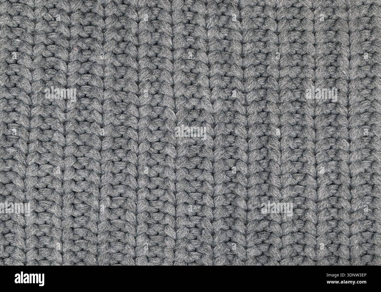 Nahtextur aus dunkelgrauem Wollstrick. Weiches Strickmaterial mit vertikalem Rippenmuster. Kuscheliger Wintertextil-Hintergrund. Stockfoto