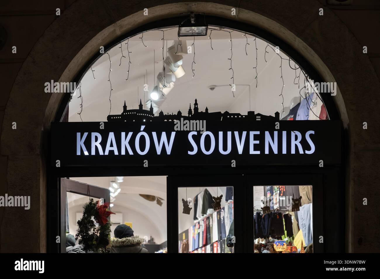 Krakau, Polen - 30. November 2025: Helles Krakauer Souvenirs-Ladenschild über einem bogenförmigen Eingang, das die berühmte Skyline der Stadt zeigt und das einzigartige Polis betont Stockfoto