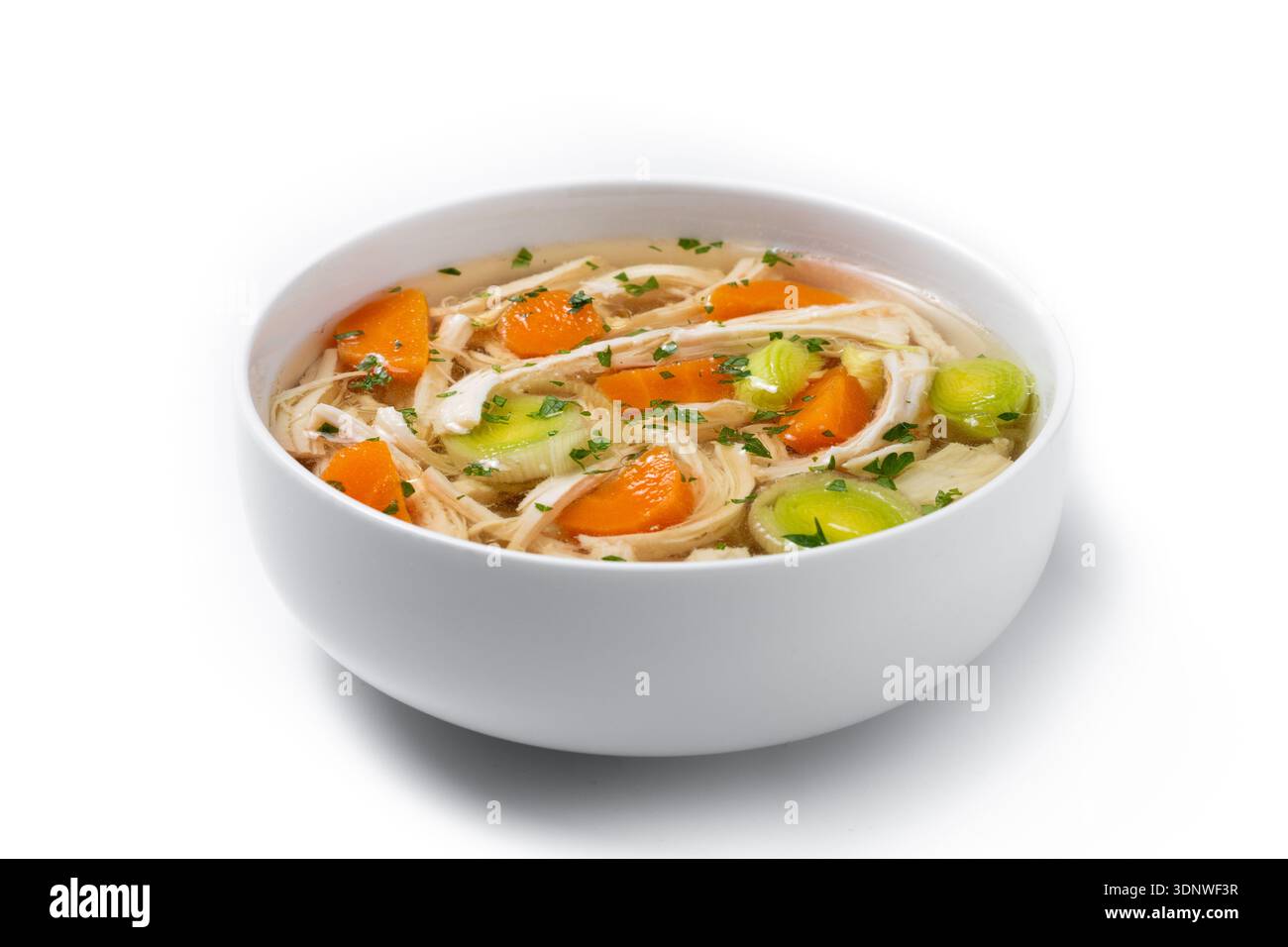 Frische hausgemachte Hühnersuppe in einer weißen Schüssel mit gehacktem Hühnchen, Karotten und Sellerie in klarer Brühe. Stockfoto