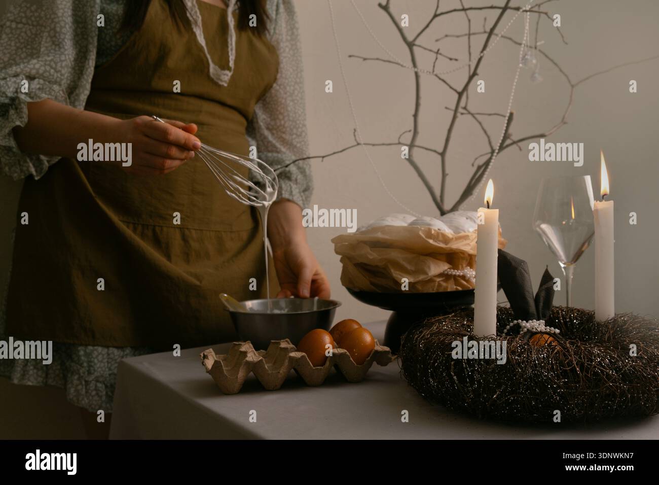 Warme Ostertraditionen, Frau, die sorgfältig das Zuckerglas für festliche Osterkuchen in einer gemütlichen Küche zubereitete. Stockfoto