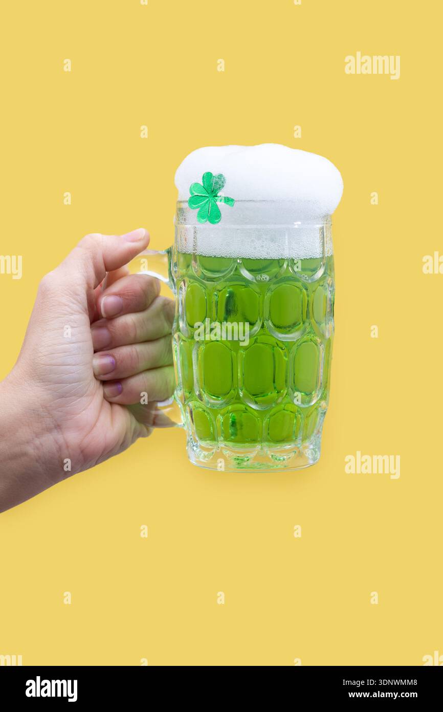 Grüner Bierkrug mit Schaum für St. Patrick’s Day auf gelbem Hintergrund Stockfoto