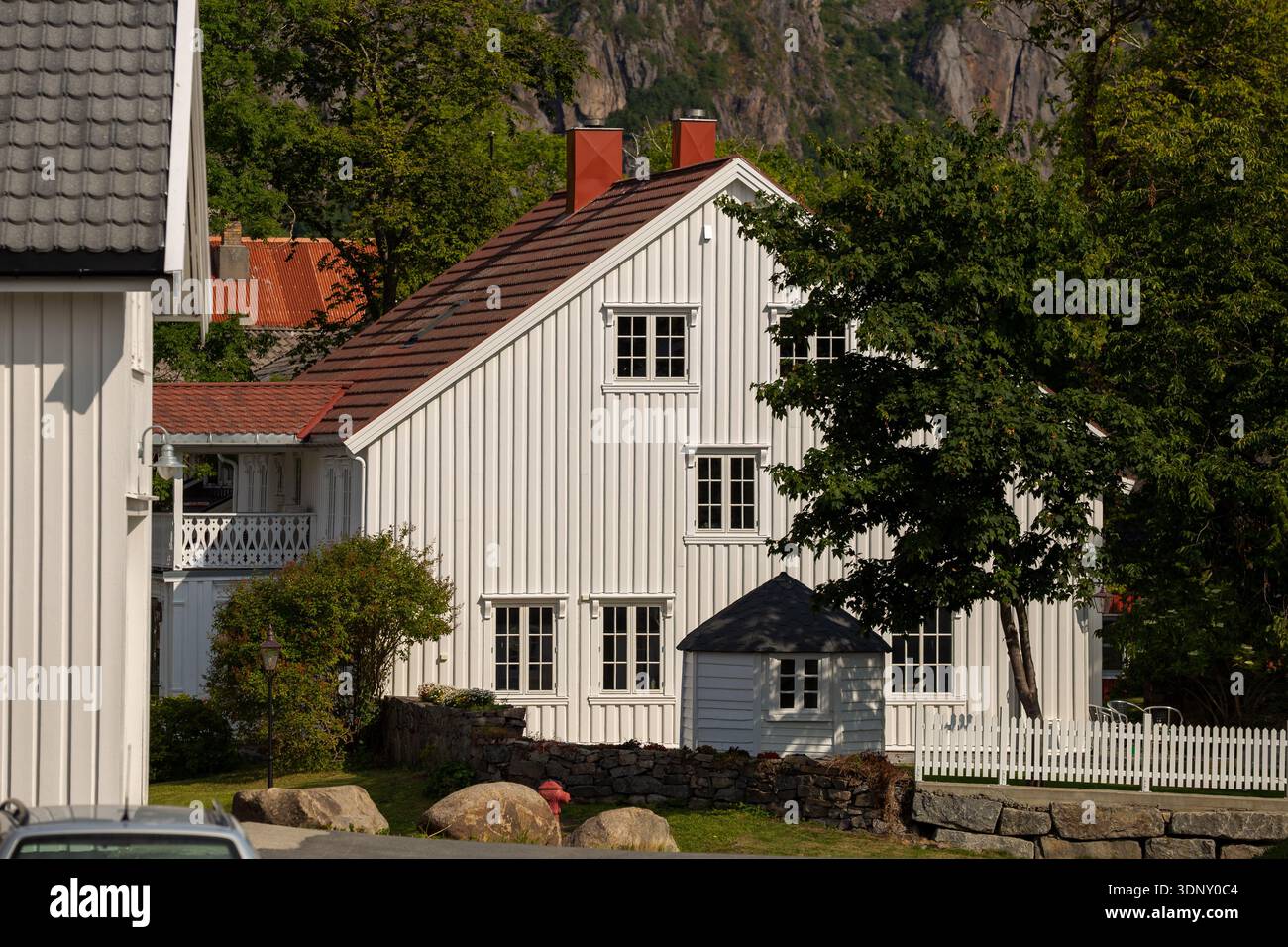Ein malerisches weißes Haus, eingebettet in üppiges Grün auf den malerischen Lofoten-Inseln, Norwegen, mit traditioneller Architektur inmitten natürlicher Schönheit. Stockfoto