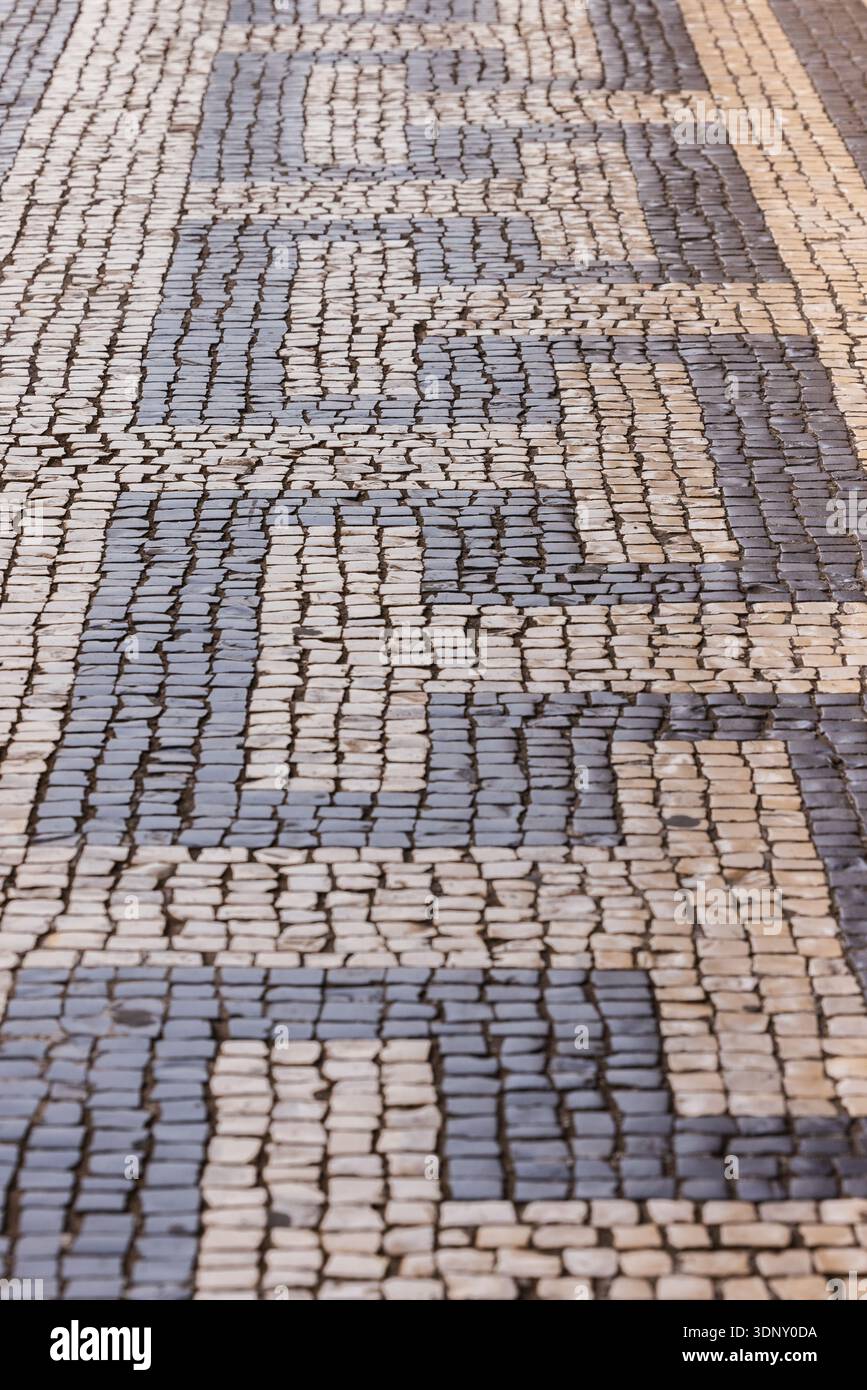Nahaufnahme eines traditionellen portugiesischen Calcada-Gehwegs in Lissabon, der die komplizierten schwarz-weißen Mosaikmuster zeigt, die typisch für Viertel wie Ba sind Stockfoto