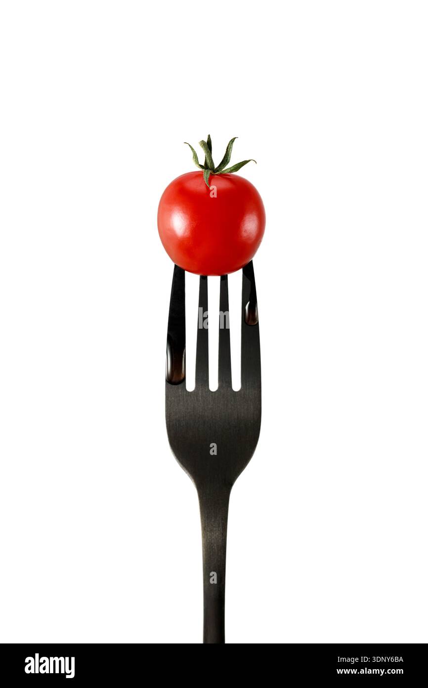 Frische rote Kirschtomate auf schwarzer Gabel isoliert auf weißem Hintergrund Stockfoto