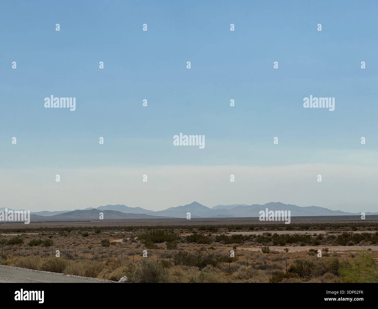 Wüstenebene mit weit entfernten Gebirgszügen unter klarem Himmel im amerikanischen Südwesten, USA. Stockfoto