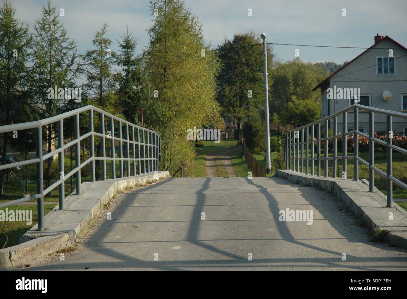 Kleine Betonbrücke mit Metallgeländern über einen Bach im Dorf Tyrawa Solna, Woiwodschaft Unterkarpaten, Polen. Stockfoto