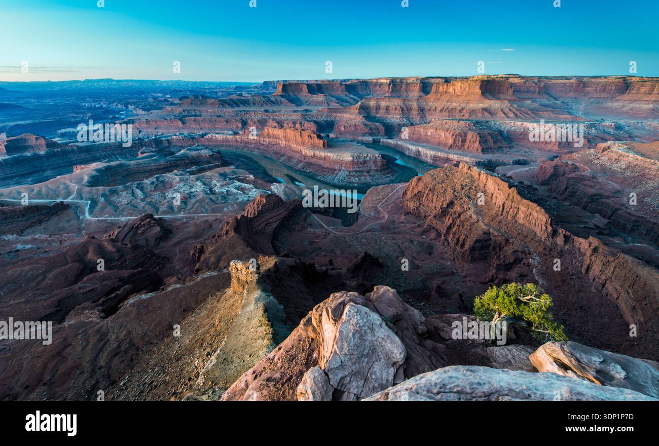 Der Colorado River schlängelt sich durch das riesige Canyonsystem des Canyonlands National Park, wie man vom Dead Horse Point State Park aus in einem dramatischen schwarzen... Stockfoto