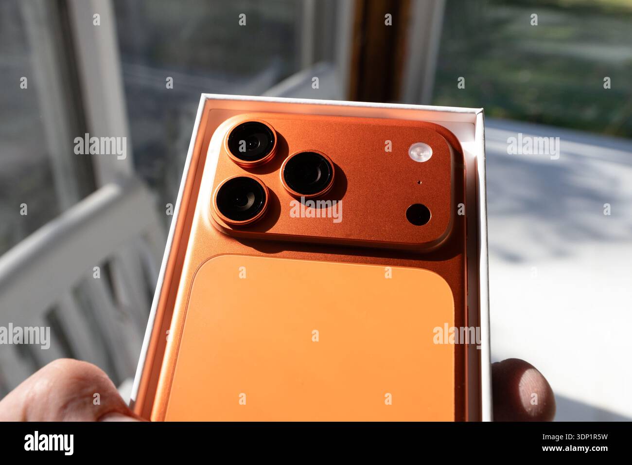 Das iPhone 17 Pro Max in Cosmic Orange ist neu und in der Verpackung, die das schlanke neue Design, die Farbe und die neue Kamerakonfiguration des neuesten Modells veranschaulicht Stockfoto