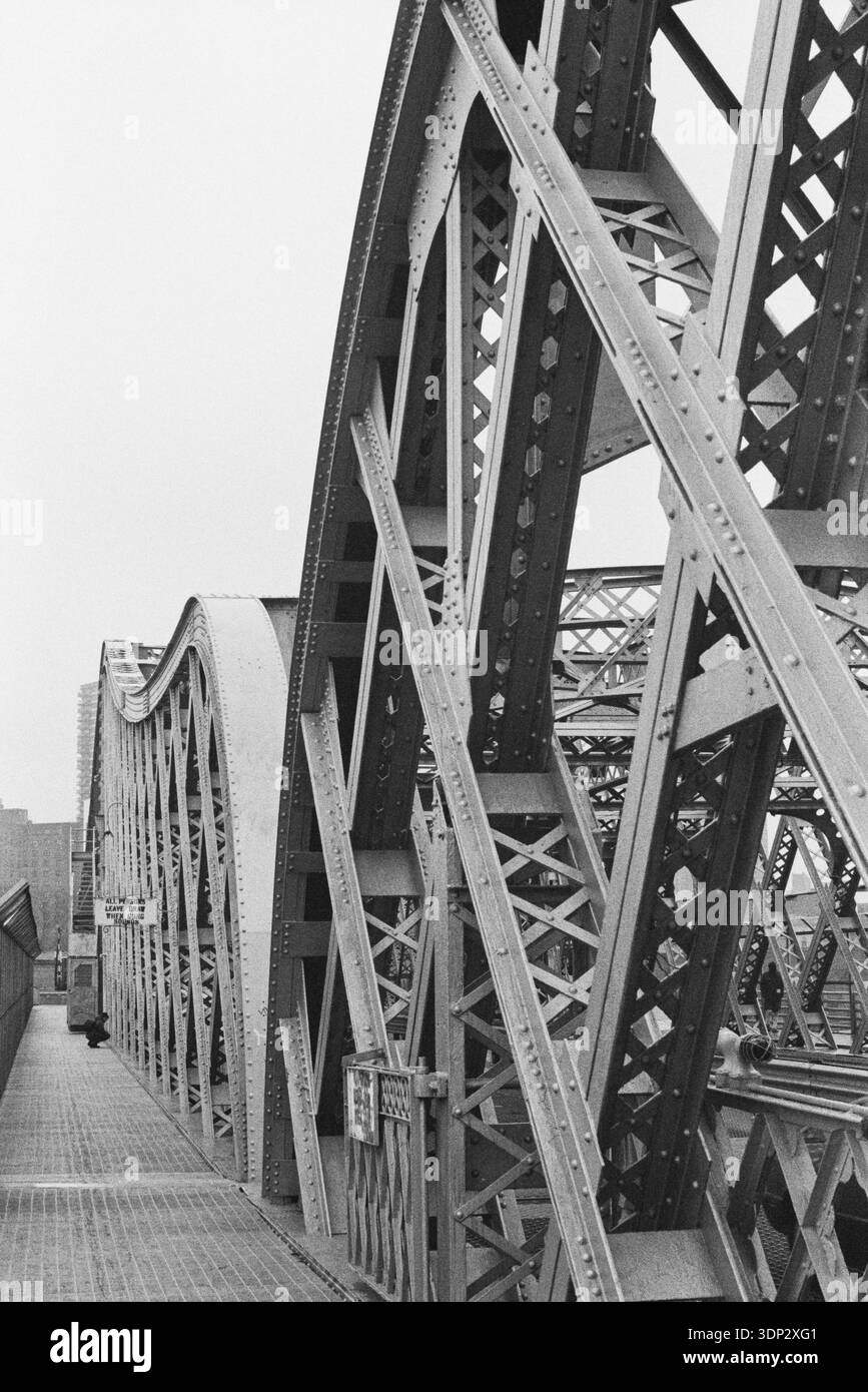 Flacher Blick auf die Stahlbögen und Gitterarbeiten der Washington Bridge, Februar 1991, mit einer Bulova-Werbetafel über dem Harlem River, NYC. Stockfoto