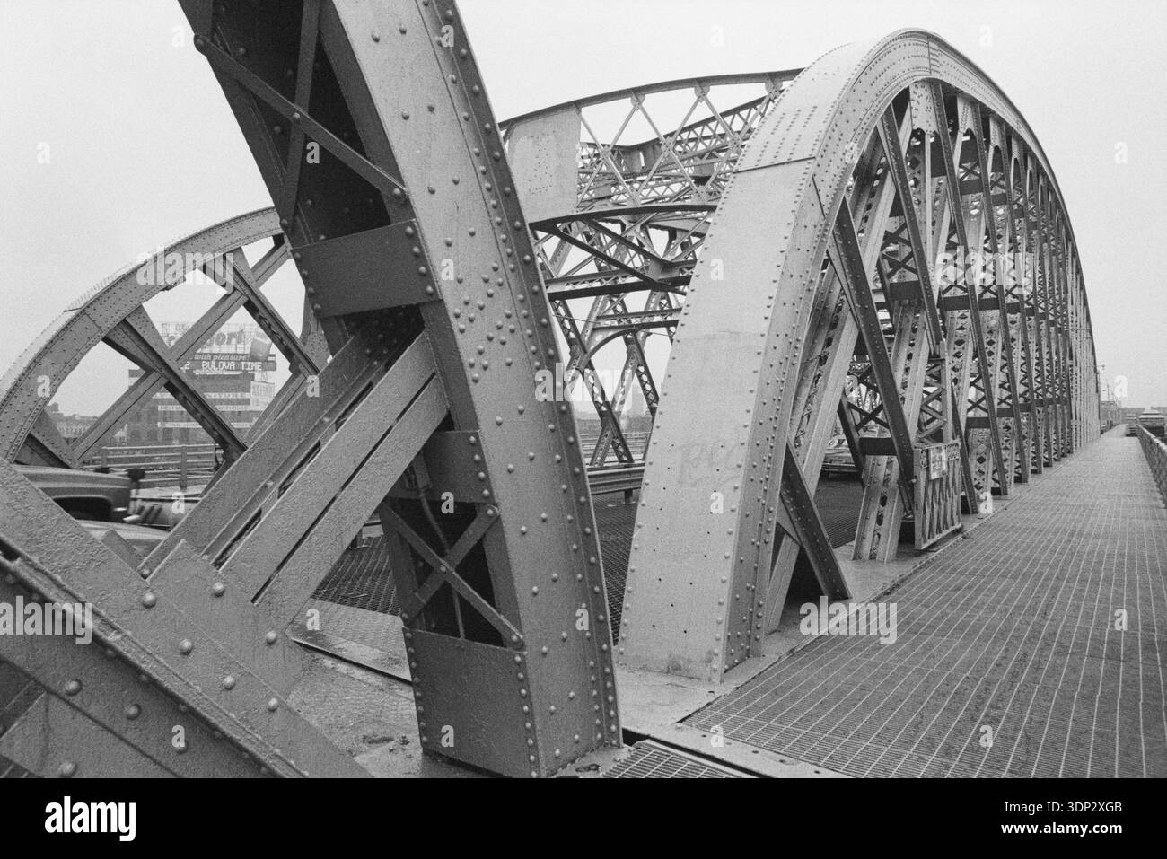 Flacher Blick auf die Stahlbögen und Gitterarbeiten der Washington Bridge, Februar 1991, mit einer Bulova-Werbetafel über dem Harlem River, NYC. Stockfoto