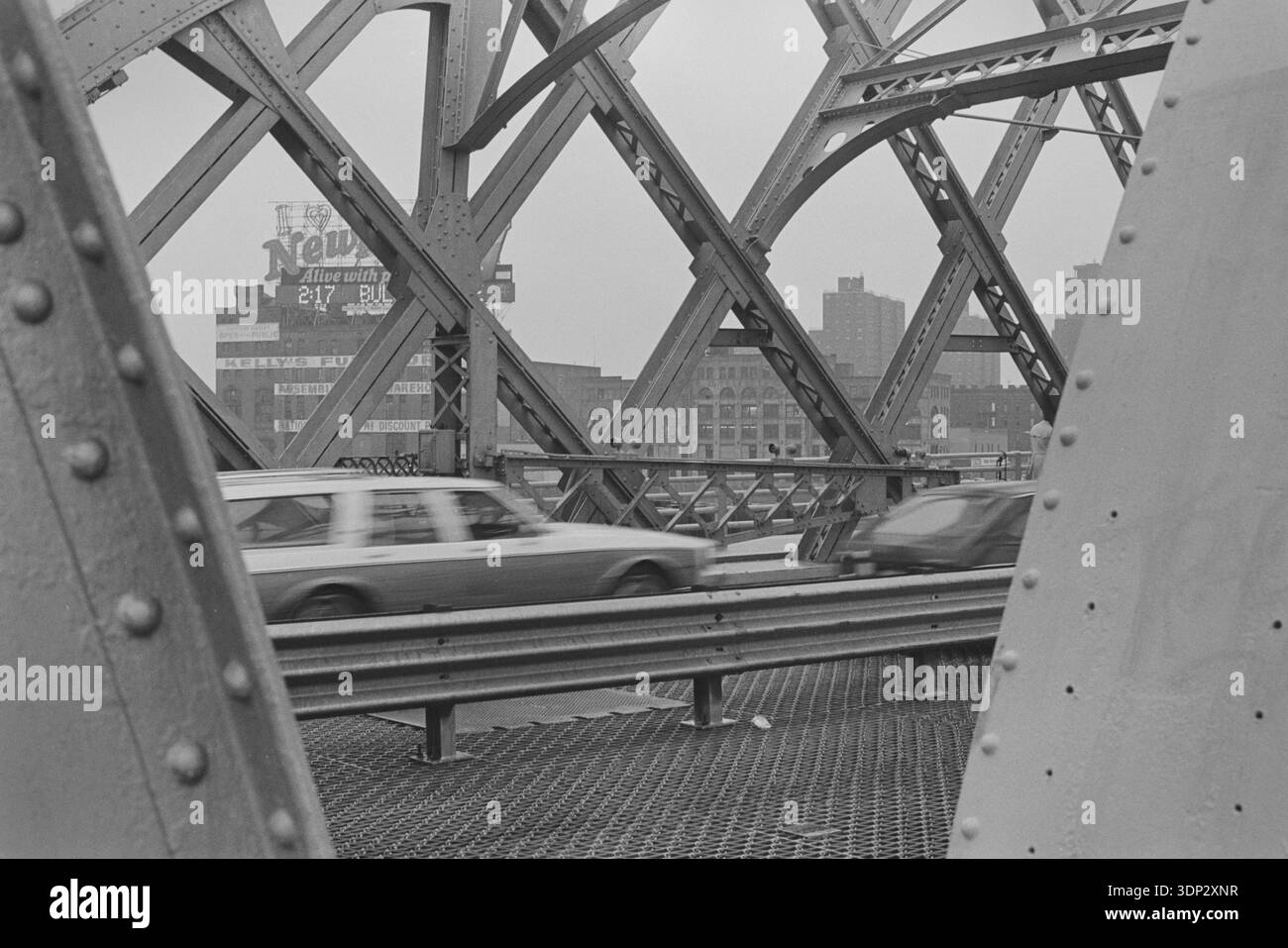 Flacher Blick auf die Stahlbögen und Gitterarbeiten der Washington Bridge, Februar 1991, mit einer Bulova-Werbetafel über dem Harlem River, NYC. Stockfoto