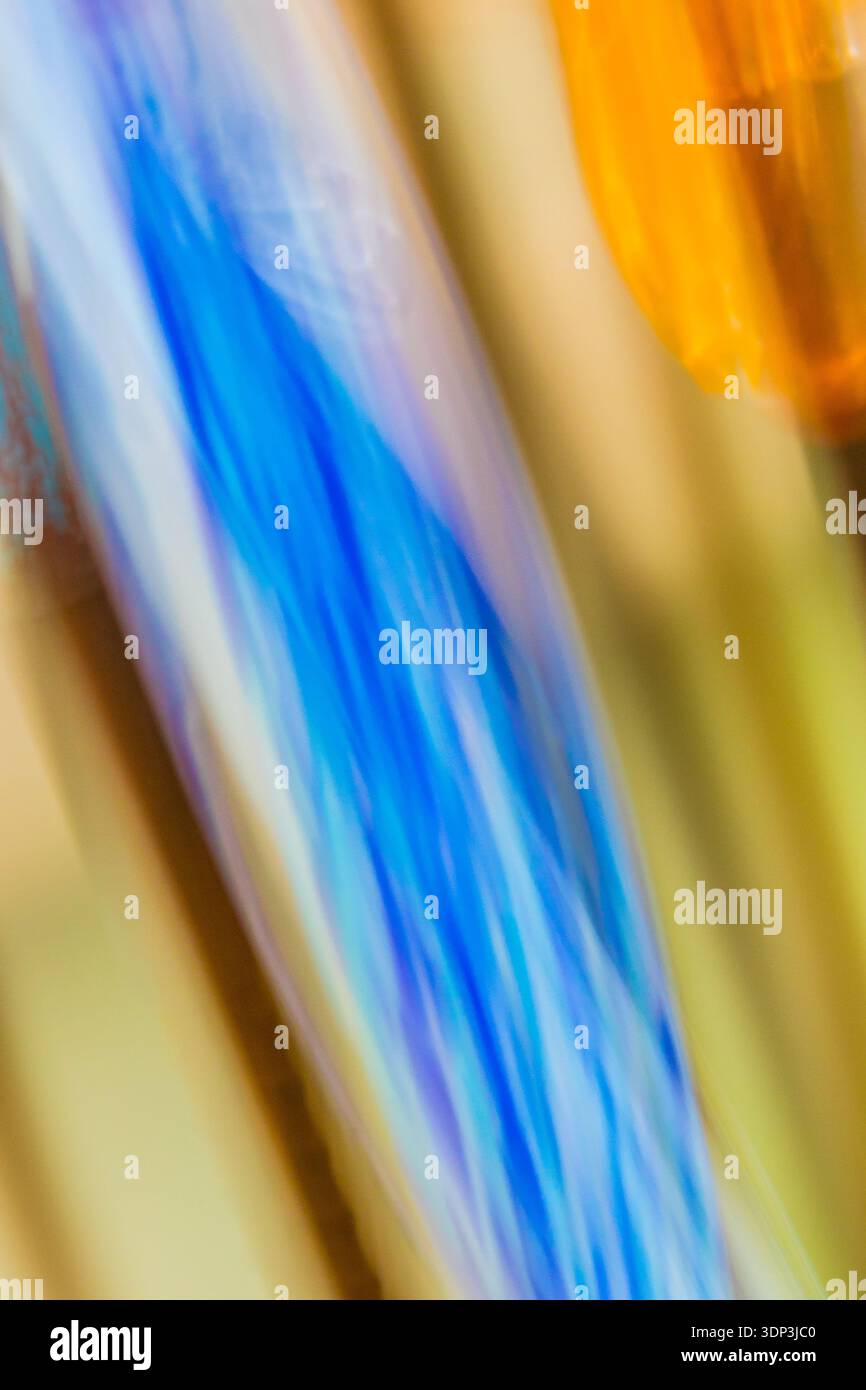 Ein Blitz von elektrischem Blau reißt diagonal durch ein Feld aus geschmolzenem Orange und Bernstein wie ein Blitz, das altes Harz spaltet. Diese auffällige ICM-Abstra... Stockfoto