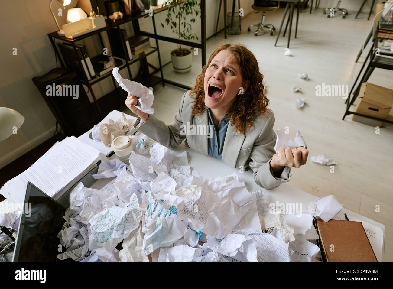 Junge Frau mit Stress während der Arbeit im Büro Stockfoto